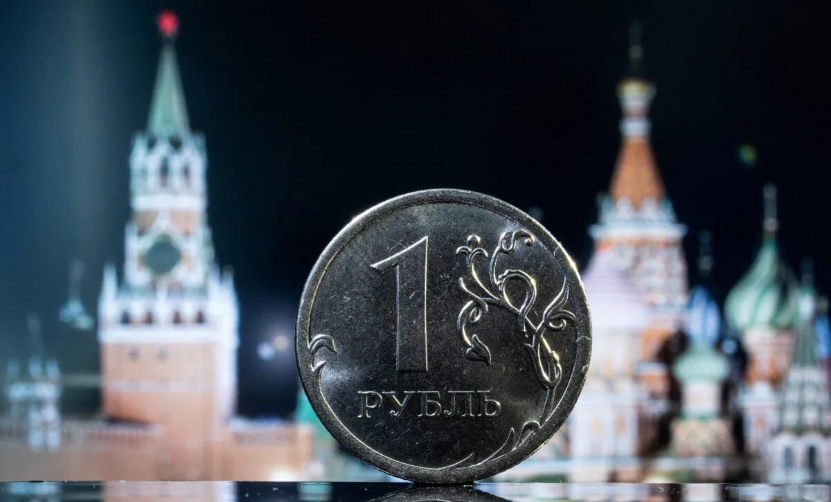 A Russian one rouble coin is pictured in front of a monitor showing St. Basil's Cathedral and a tower of Moscow's Kremlin in this illustration taken on June 24, 2022. (Maxim Shemetov/Illustration/Reuters)