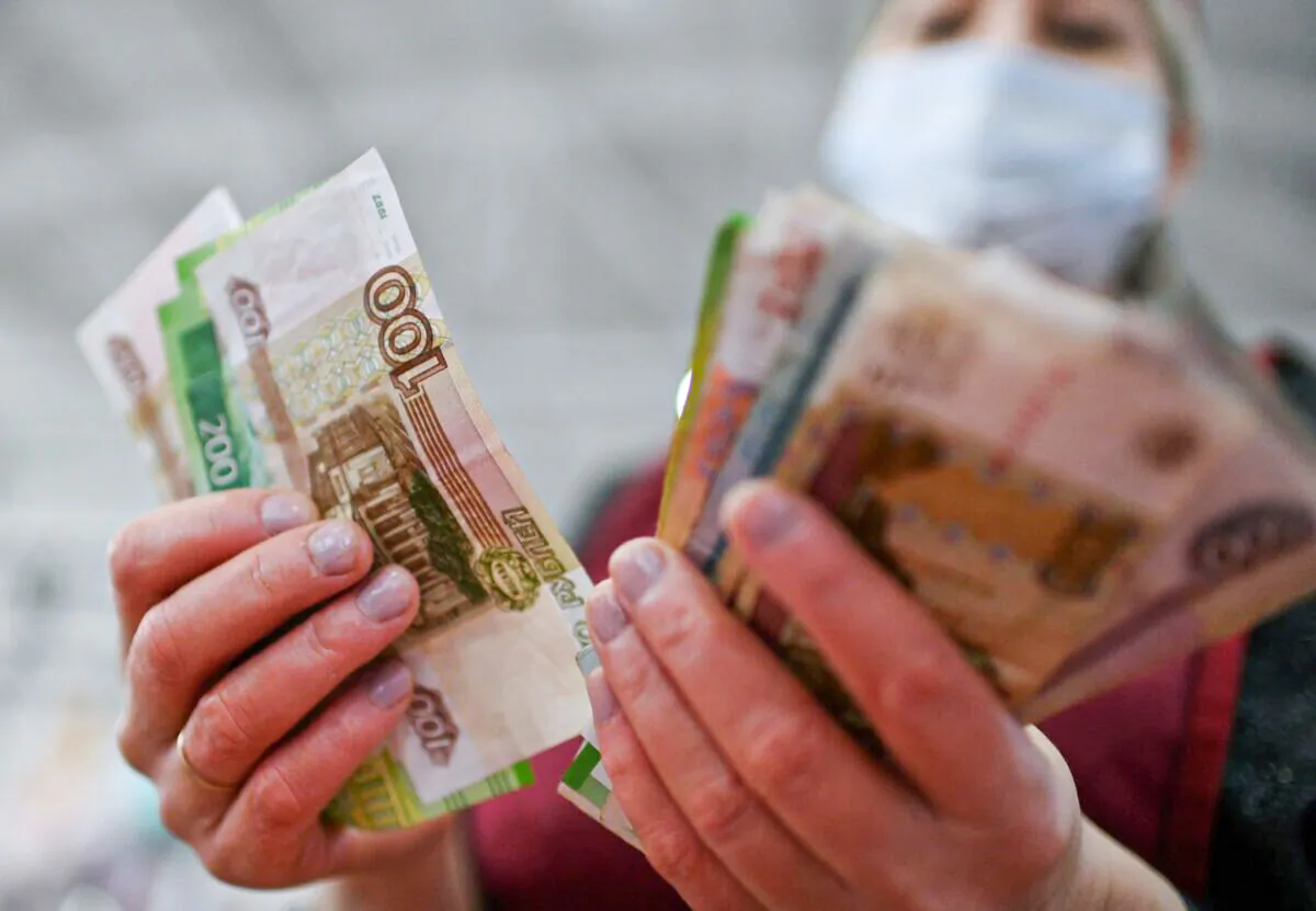 A vendor counts Russian rouble banknotes at a market in Omsk, Russia, on Feb. 18, 2022. (Alexey Malgavko/Reuters)