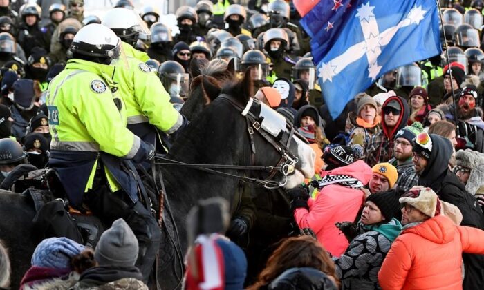 Demonstrators react as mounted police charge to disperse convoy protesters in Ottawa on Feb. 18, 2022. (The Canadian Press/Justin Tang)