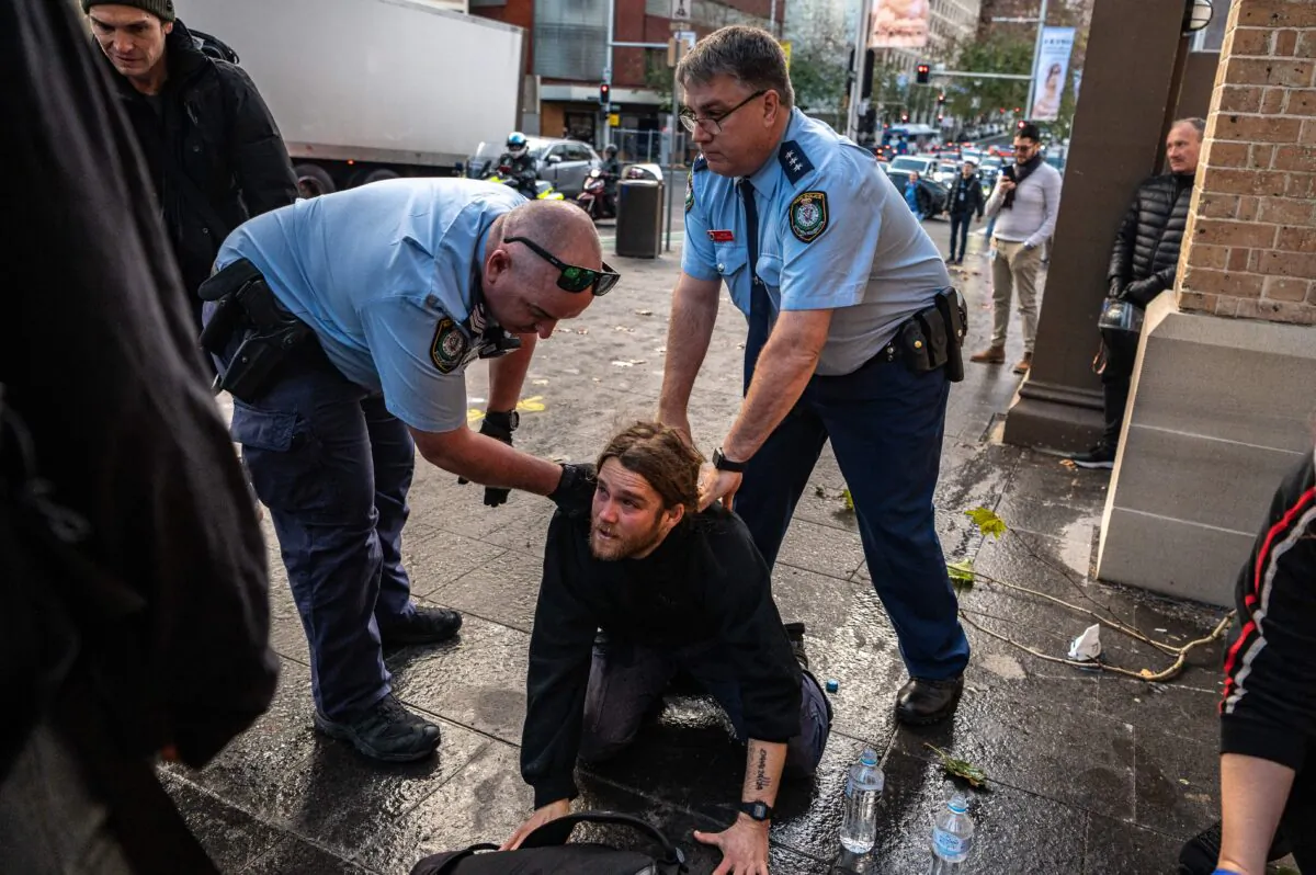 Police officers detain a protestor during a rally in Sydney. Climate activist group Blockade Australia stage a protest in Sydney, Tuesday, June 28, 2022. (AAP Image/Flavio Brancaleone)