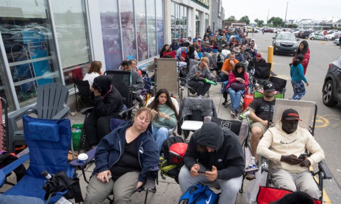 People sit in chairs to ease the long wait outside a passport office in Montreal on June 22, 2022. (The Canadian Press/Ryan Remiorz)