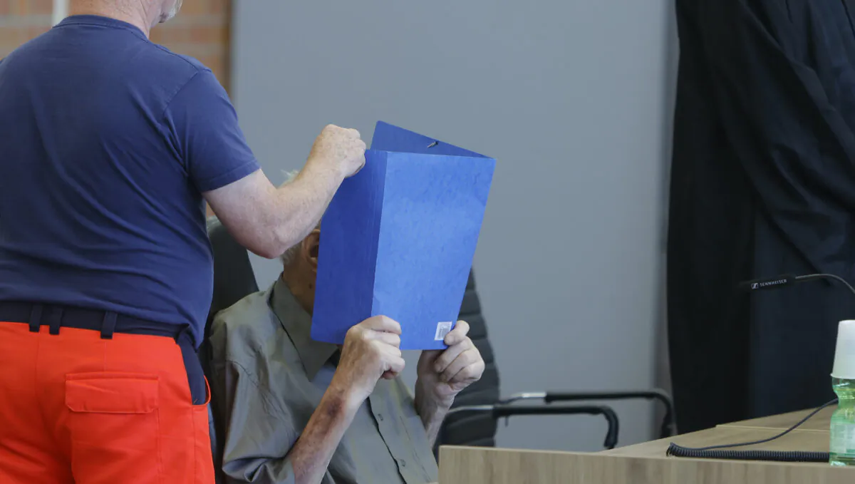 The accused Josef S. covers his face as he sits at the court room in Brandenburg, Germany, Tuesday, June 28, 2022. (AP Photo/Michele Tantussi)