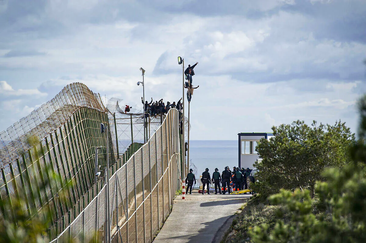 African migrants attempt to scale the fence at the border between Morocco and the North African Spanish enclave of Melilla, on April 3, 2014. (Alexander Koerner/Getty Images)