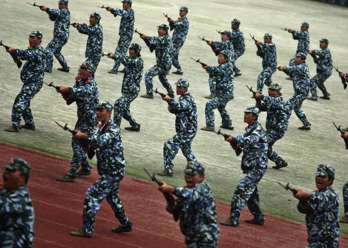 Freshmen practise fighting skills during a military training at a university in Gaochun county of Jiangsu Province, China, on Sept. 25, 2008. (China Photos/Getty Images)