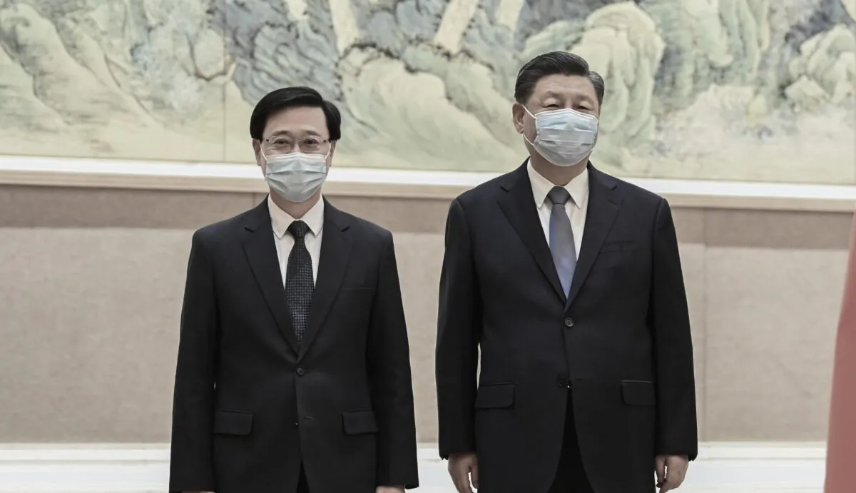 Chinese leader Xi Jinping (R) and Hong Kong Chief Executive-elect John Lee pose for a photo before their meeting in Beijing, China, on May 30, 2022. (Li Xueren/Xinhua via AP)
