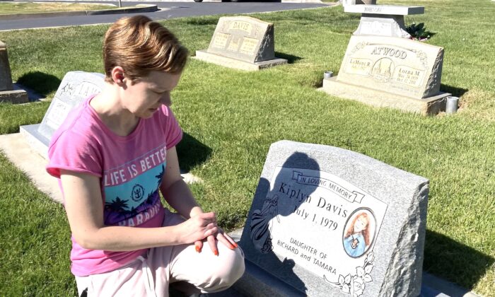Karissa Lords of Spanish Fork, Utah, kneels beside a monument to her older sister, Kiplyn Davis, who went missing on May 2, 1995 and is presumed dead. Her remains have yet to be found. (Allan Stein/The Epoch Times)