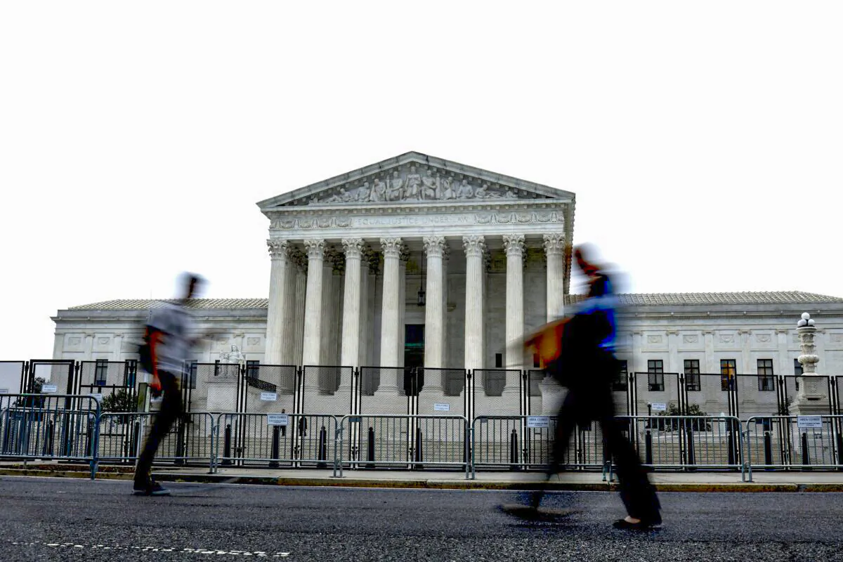 People walk past the Supreme Court building during a rainstorm in Washington, D.C., on June 23, 2022. (Anna Moneymaker/Getty Images)