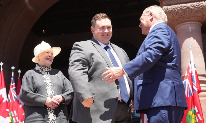 Minister of Citizenship and Multiculturalism, Michael Ford poses with Premier Doug Ford as Lieutenant-Governor of Ontario Elizabeth Dowdeswell looks on, at the swearing-in ceremony at Queen’s Park in Toronto on June 24, 2022. (The Canadian Press/Nathan Denette)