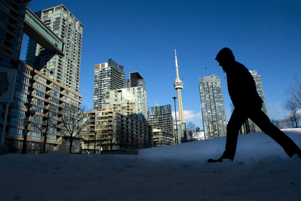 A pedestrian makes his way through condo towers in Toronto, Ontario, on Jan. 28, 2021. (Frank Gunn/The Canadian Press)