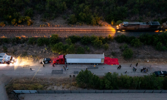Members of law enforcement investigate a tractor trailer in San Antonio, Texas, on June 27, 2022. (Jordan Vonderhaar/Getty Images)