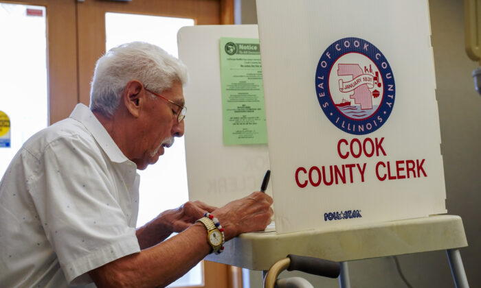 A voter fills out his ballot in Palos Hills, Ill., on June 28, 2022. (Cara Ding/The Epoch Times)