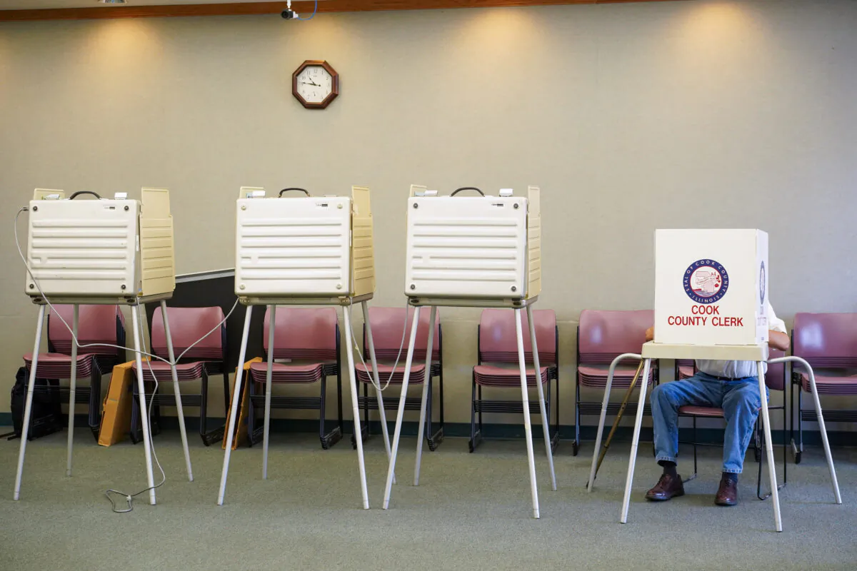 A voter fills out his ballot in Palos Hills, Ill., on primary day June 28, 2022. (Cara Ding/The Epoch Times)