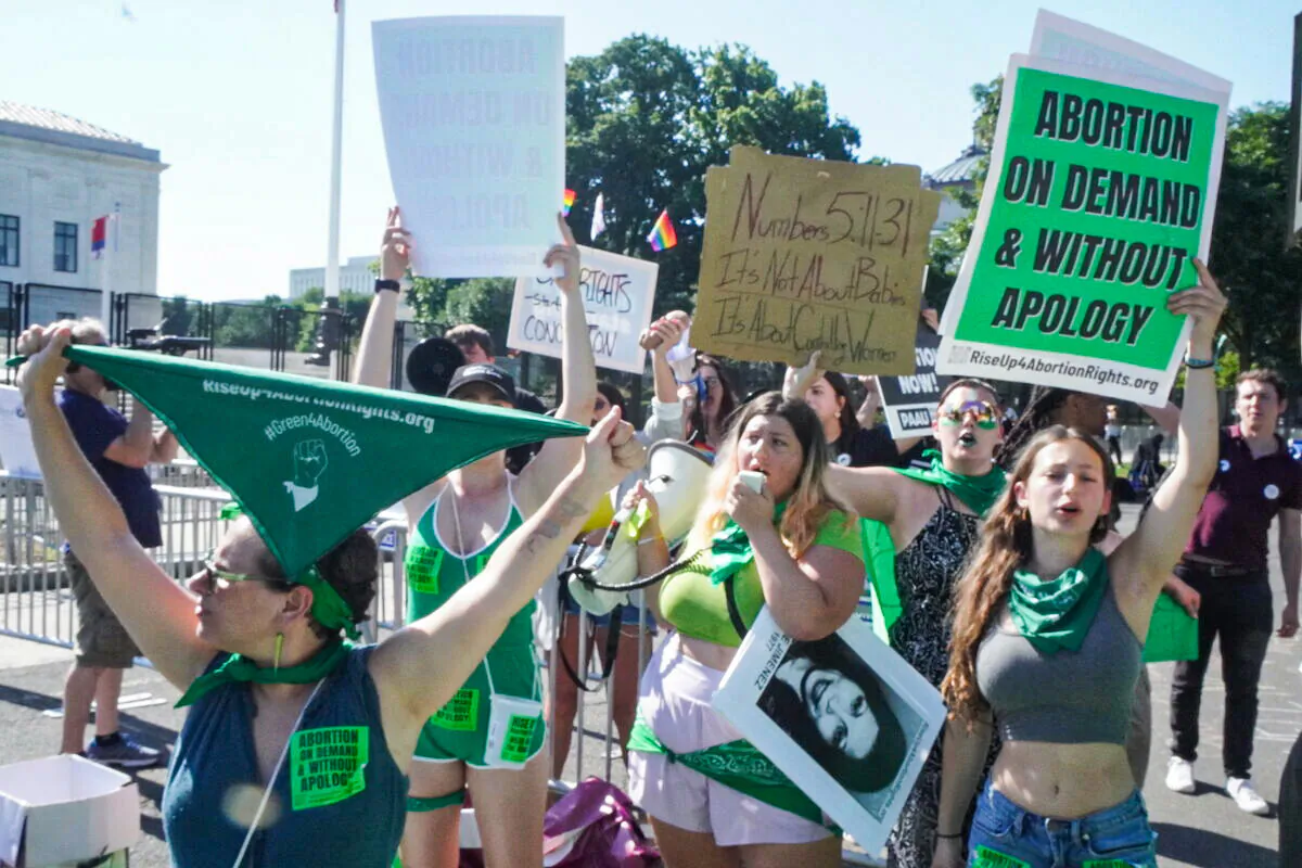 Pro-abortion supporters with Rise Up 4 Abortion Rights wear green as they protest outside the U.S. Supreme Court in Washington on June 15, 2022. (Jackson Elliott/The Epoch Times)
