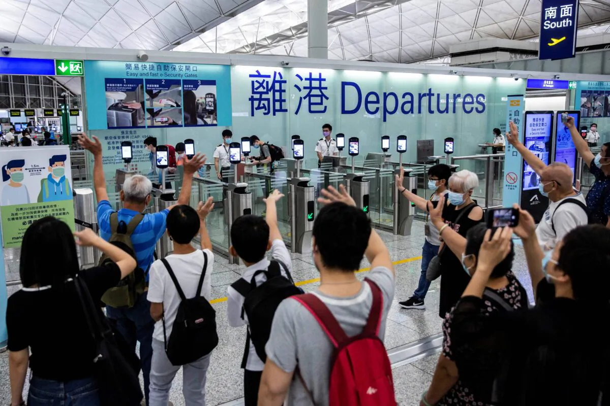 Hong Kong International Airport fills with the sound of tearful goodbyes as residents fearful for their future in Hong Kong under the increasingly authoritarian rule leave on July 22, 2021, as part of a repeating scene, to start a new life overseas, mostly in Britain. (Isaac Lawrence/AFP via Getty Images)