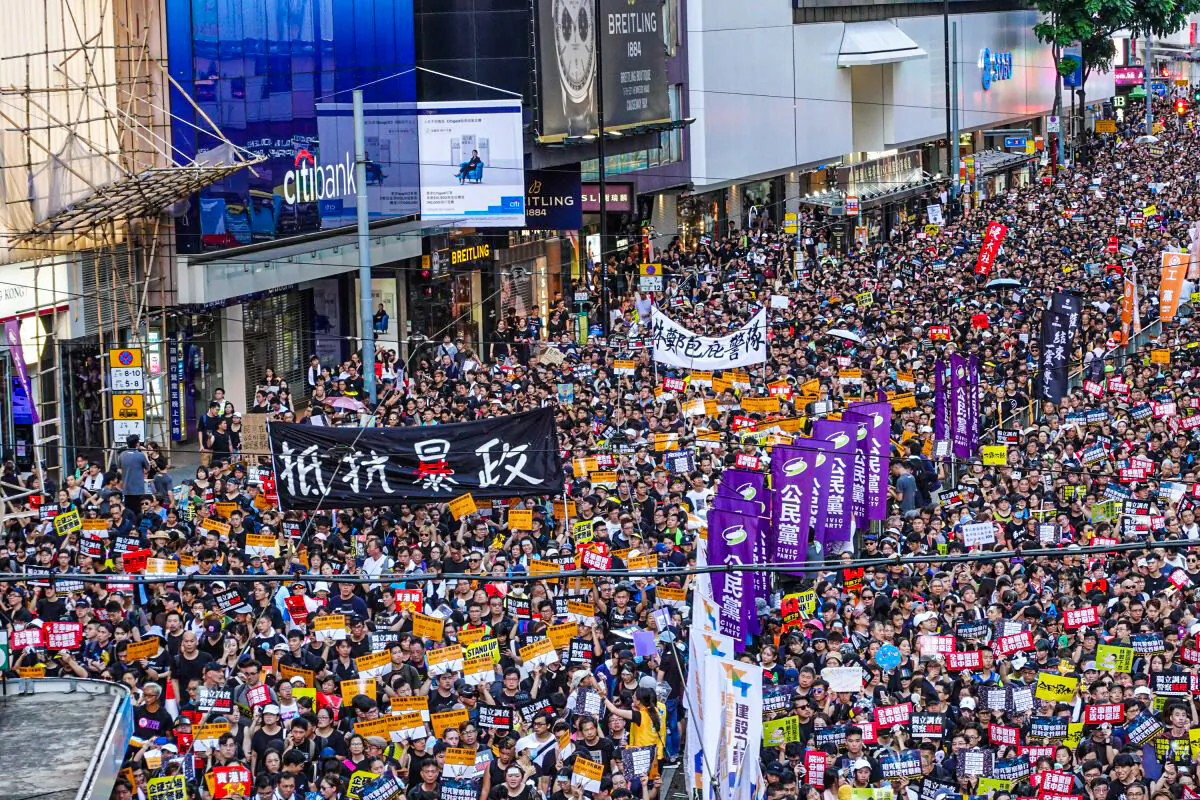 Protesters march on Hong Kong streets with a sign that reads 'Resist Tyranny' during a pro-democracy rally on July 1, 2019. (Yu Gang/The Epoch Times)
