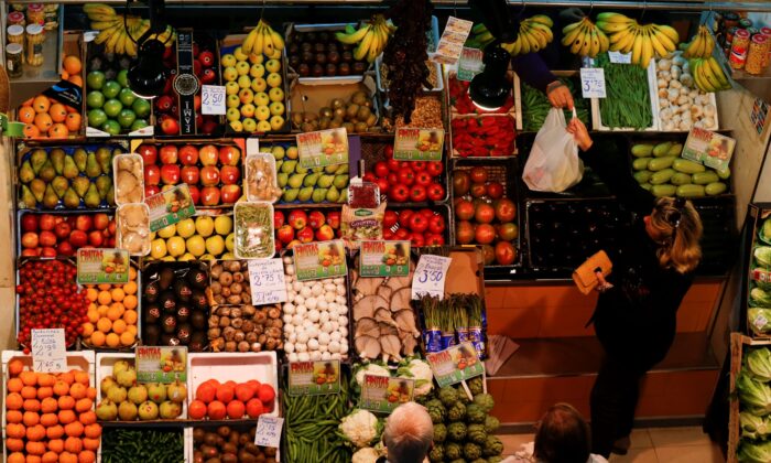A woman buys in a fruits and vegetables shop at a food market in the Andalusian capital of Seville, southern Spain, on March 7, 2016. (Marcelo del Pozo/Reuters)