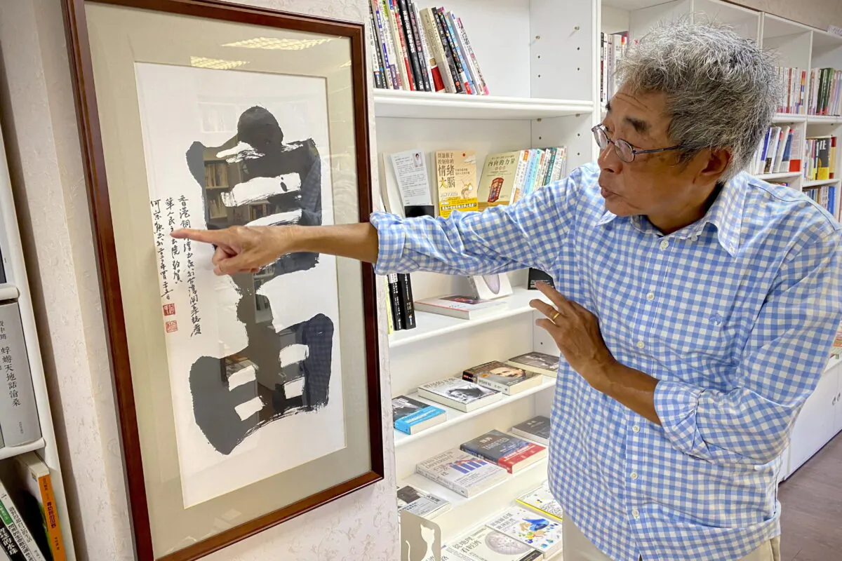 Lam Wing-Kee, a Hong Kong bookstore owner who fled to Taiwan in 2019, gestures at calligraphy with the words "Freedom" during an interview inside his bookstore in Taipei, Taiwan, on June 8, 2022. (Johnson Lai/AP Photo)