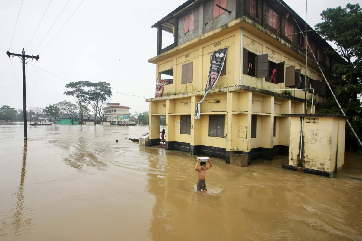 A boy wades through a flooded area during a widespread flood in the northeastern part of the country, in Sylhet, Bangladesh, on June 19, 2022. (Stringer/Reuters)