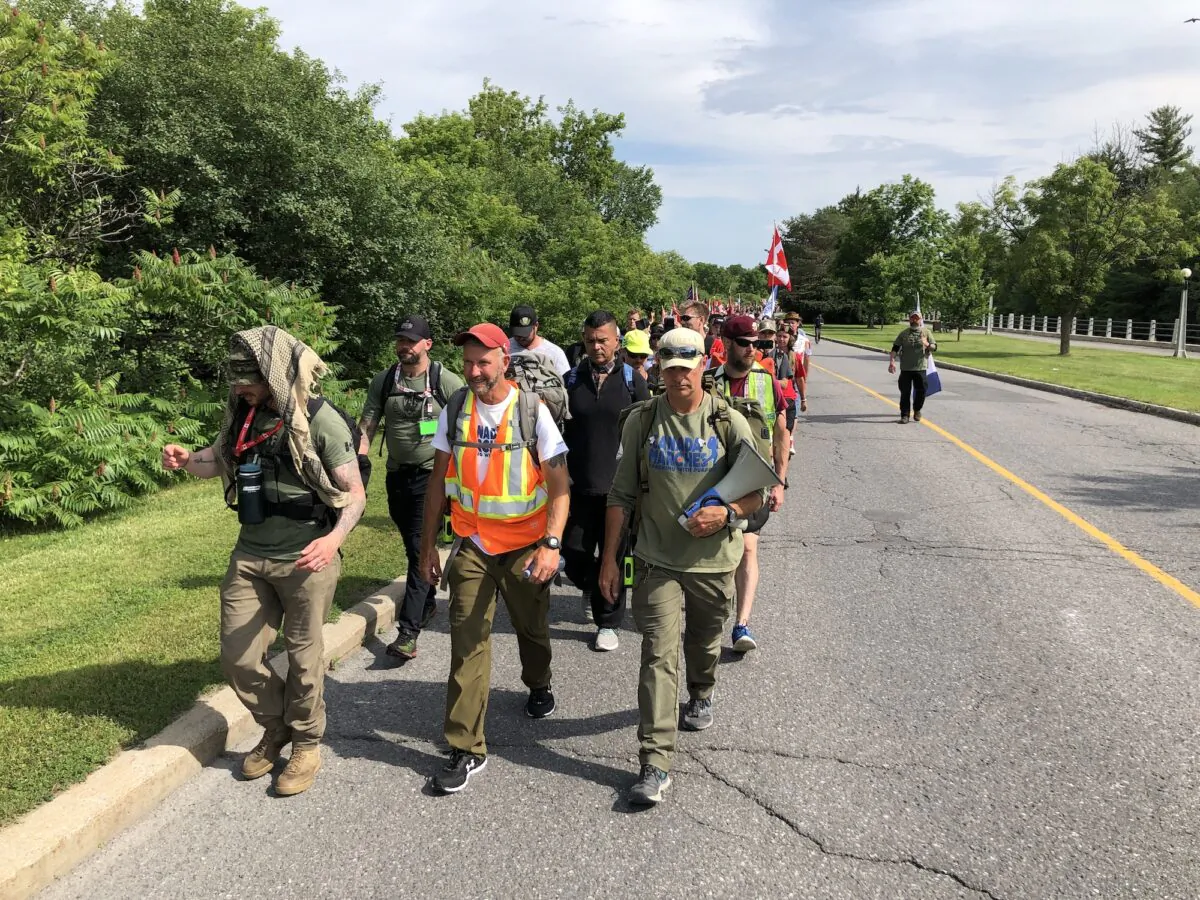 Military veteran James Topp walks with supporters toward his last stop, the War Memorial in Ottawa, on June 30, 2022. (Noé Chartier/The Epoch Times)