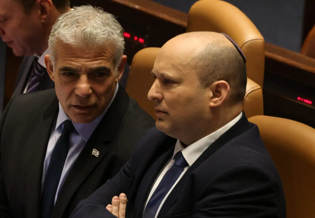 Israeli Minister of Foreign Affairs Yair Lapid (L) speaks to outgoing Prime Minister Naftali Bennett, during a meeting at the Knesset (parliament), in Jerusalem on June 30, 2022. (Menahem Kahana/AFP via Getty Images)