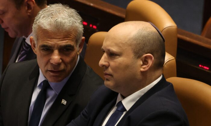Israeli Minister of Foreign Affairs Yair Lapid (L) speaks to outgoing Prime Minister Naftali Bennett, during a meeting at the Knesset (parliament), in Jerusalem on June 30, 2022. (Menahem Kahana/AFP via Getty Images)
