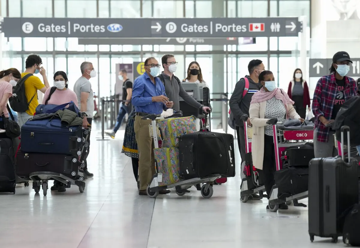 People wait in line to check in at Pearson International Airport in Toronto on May 12, 2022. (The Canadian Press/Nathan Denette)
