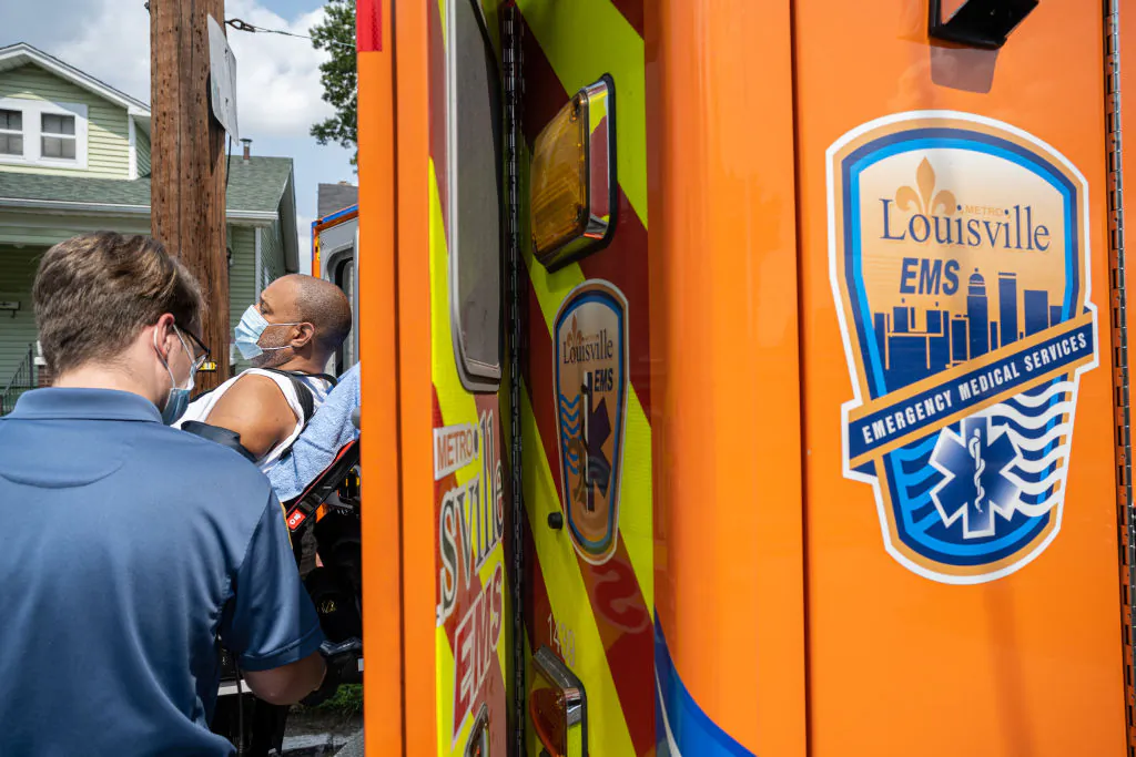 Members of Louisville Metro Emergency Medical Services load a patient experiencing a suspected COVID-19 emergency into an ambulance outside the patient's home on September 13, 2021 in Louisville, Kentucky. (Photo by Jon Cherry/Getty Images)