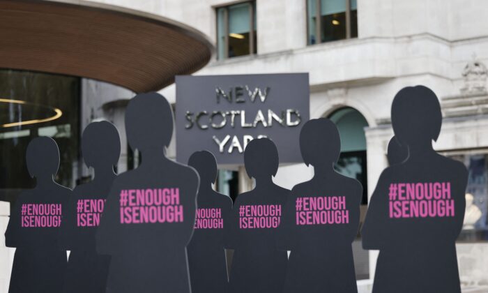 Cut-out silhouettes representing women are set up outside the Metropolitan Police headquarters New Scotland Yard in an action by Refuge, the domestic abuse charity, to highlight the issue of women who have been killed by male police officers or former police officers, in London on Oct. 7, 2021. (Tolga Akmen/AFP via Getty Images)