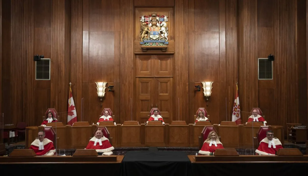 Justices of the Supreme Court pose for a photo sitting in the Supreme Court following a welcoming ceremony, October 28, 2021 in Ottawa. (The Canadian Press/Adrian Wyld)