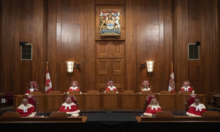 Justices of the Supreme Court pose for a photo sitting in the Supreme Court following a welcoming ceremony, October 28, 2021 in Ottawa. (The Canadian Press/Adrian Wyld)