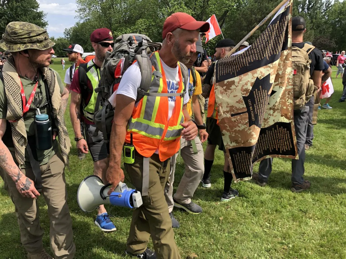Military veteran James Topp walks with supporters toward his last stop on his march to protests vaccine mandates, the War Memorial, in Ottawa, on June 30, 2022. (Noé Chartier/The Epoch Times)