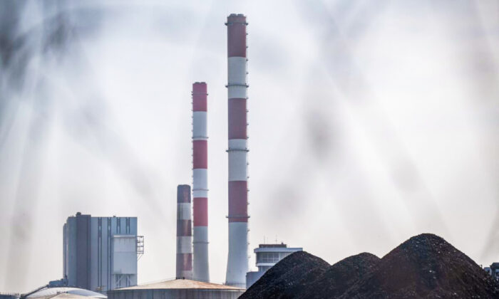 A coal pile in front of the chimneys of a coal plant in France on March 27, 2022. (Loic Venance/AFP via Getty Images)
