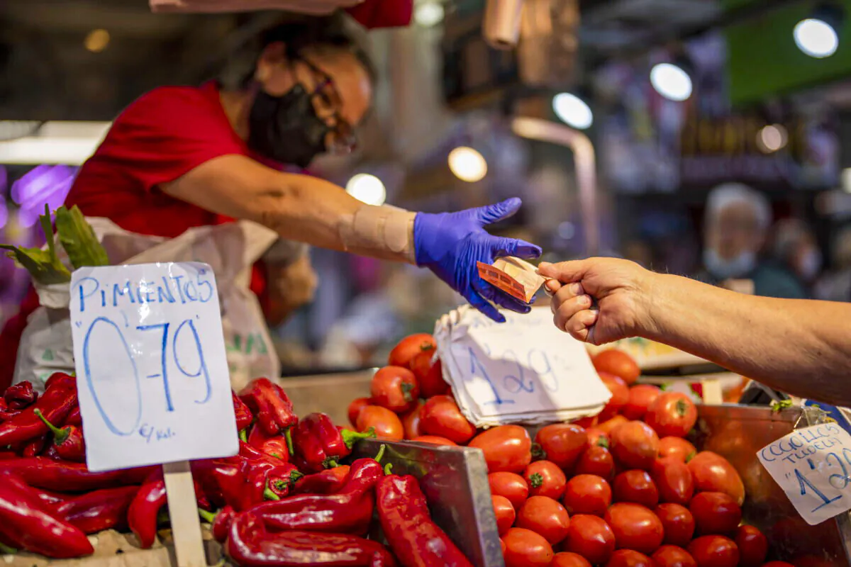 A customer pays for vegetables at the Maravillas market in Madrid, Spain, on May 12, 2022.  (AP Photo/Manu Fernandez, File)
