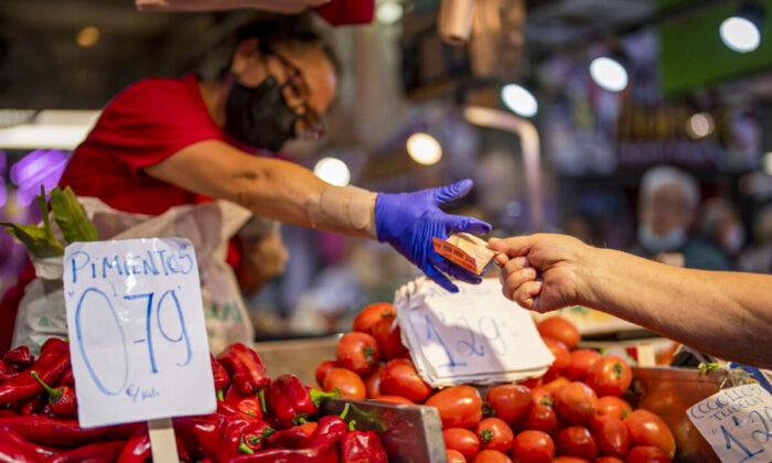 A customer pays for vegetables at the Maravillas market in Madrid, Spain, on May 12, 2022.  (AP Photo/Manu Fernandez, File)