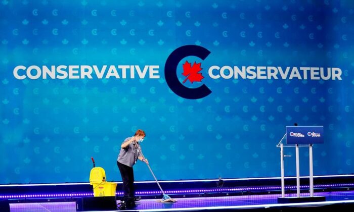 A woman cleans the stage at then-Conservative Leader Erin O'Toole's election night headquarters during the Canadian federal election in Oshawa, Ont., on Sept. 20, 2021. (The Canadian Press/Adrian Wyld)