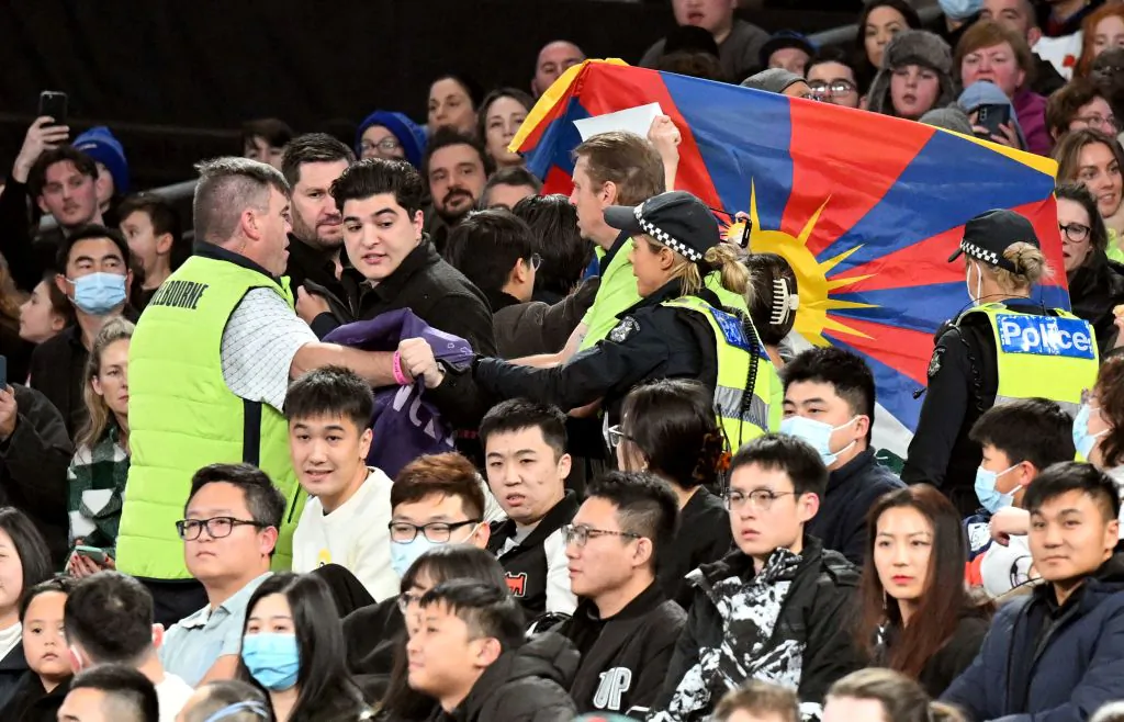 Members of security (in yellow) try to remove protesters from the stadium during the FIBA Basketball World Cup 2023 qualifying game between Australia and China in Melbourne on June 30, 2022. (William West/AFP via Getty Images)