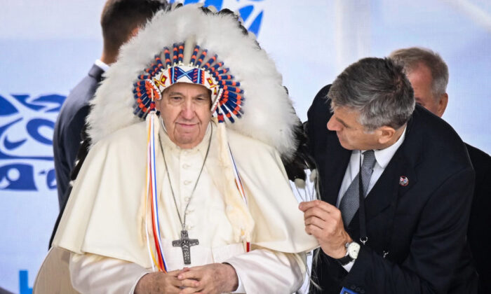 Pope Francis wears a headdress presented to him by Indigenous leaders during a meeting at Muskwa Park in Maskwacis, Alberta, Canada, on July 25, 2022. (Patrick T. Fallon/AFP via Getty Images)
