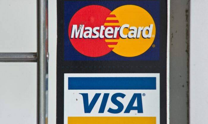 Visa and MasterCard credit card logos are seen in a store window in Washington on March 30, 2012. (Nicholas Kamm/AFP via Getty Images)