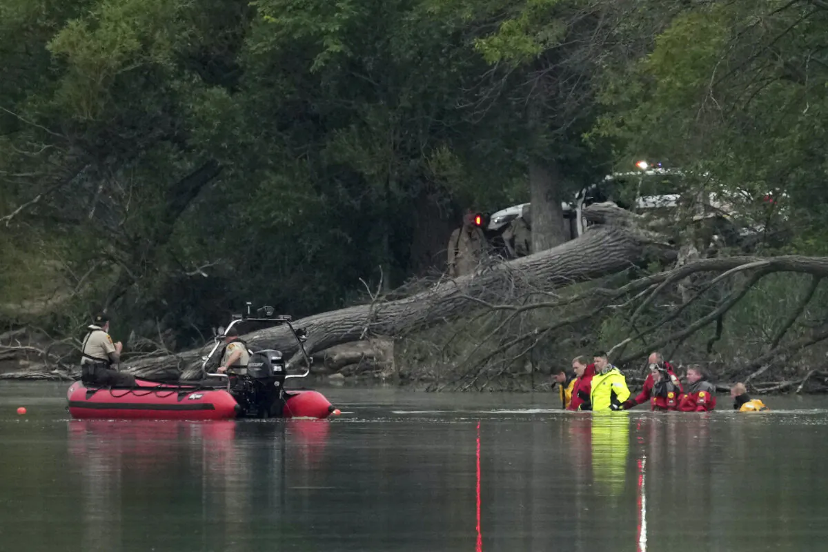 Teams in dry suits and Ramsey County Sheriff's deputies search for the bodies of a mother and her three children at Vadnais Lake in Vadnais Heights on July 2, 2022. (Anthony Souffle/Star Tribune via AP)