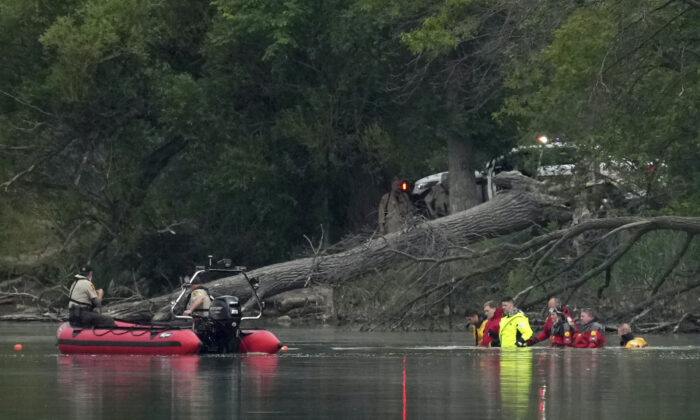 Teams in dry suits and Ramsey County Sheriff's deputies search for the bodies of a mother and her three children at Vadnais Lake in Vadnais Heights on July 2, 2022. (Anthony Souffle/Star Tribune via AP)