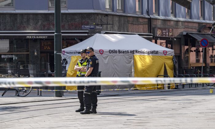 Police stand near a restaurant whose windows were shattered by a shooting in Oslo, Norway, on June 25, 2022. (Rodrigo Freitas/Getty Images)
