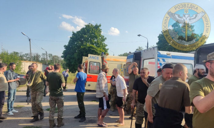 Ukrainian soldiers stand next to ambulances as Ukraine carries out an exchange of prisoners in the location given as Zaporizhzhia, Ukraine, in this handout photo released on June 29, 2022. (Courtesy of Ukraine's Military Intelligence/Handout via Reuters)