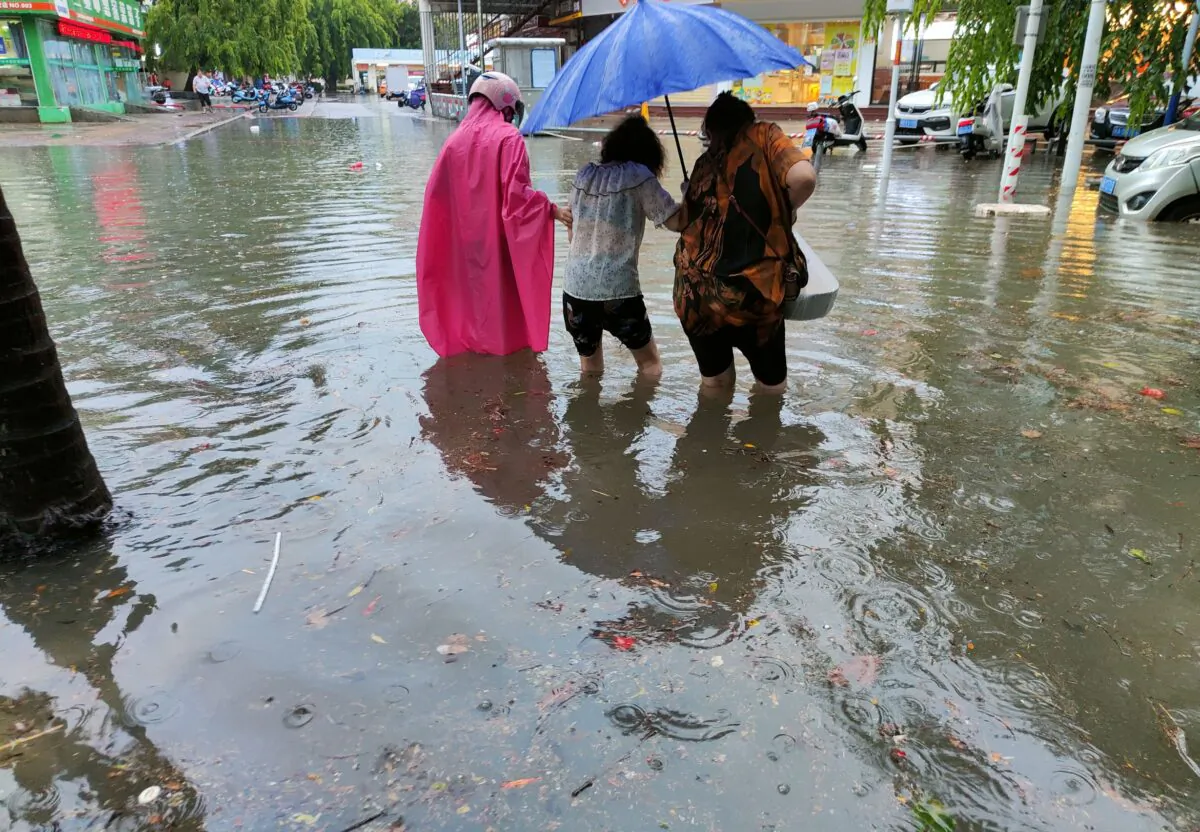 Pedestrians wade through floodwaters on a street amid heavy rainfall as Typhoon Chaba hits Sanya in Hainan Province, China, on July 2, 2022. (CNS photo via Reuters)
