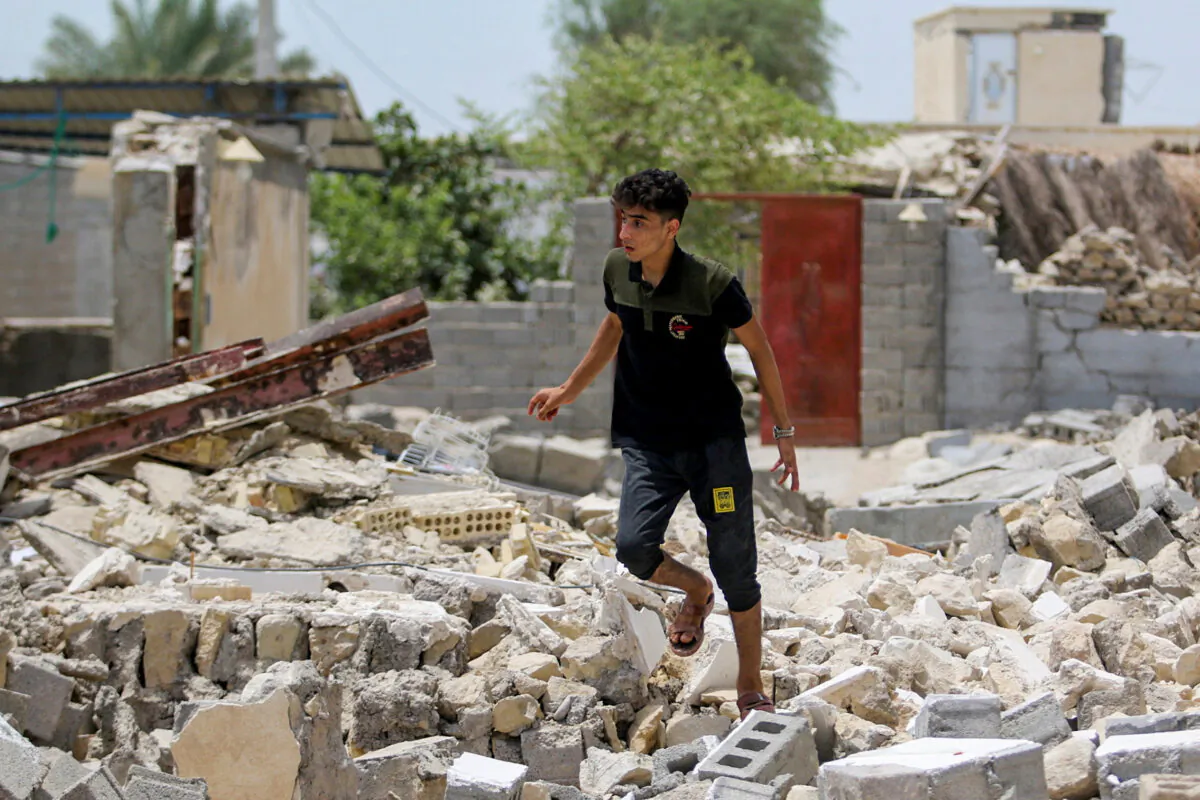 An Iranian man walks amid the rubble after an earthquake in Sayeh Khosh village in Hormozgan, Iran, on July 2, 2022. (ISNA/West Asia News Agency via Reuters)