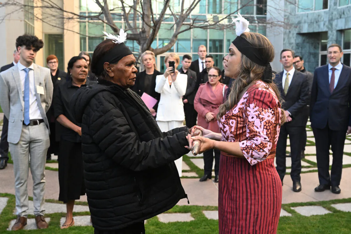 Country Liberal Party Senator Jacinta Price (R) is handed a nalanala (fighting stick that represents country) by grandmother Tess Napaljarri Ross (L) during an indigenous ceremony at Parliament House in Canberra, Australia, on July 27, 2022. (AAP Image/Mick Tsikas)