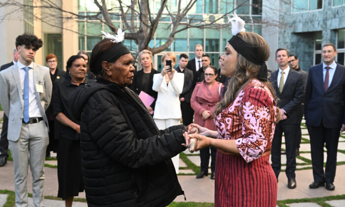 Country Liberal Party Senator Jacinta Price (R) is handed a nalanala (fighting stick that represents country) by grandmother Tess Napaljarri Ross (L) during an indigenous ceremony at Parliament House in Canberra, Australia, on July 27, 2022. (AAP Image/Mick Tsikas)