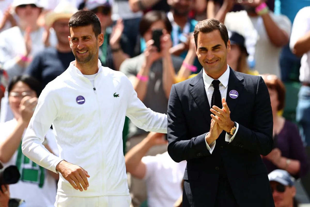 Swiss tennis player Roger Federer (R) and Serbia's Novak Djokovic take part in the Centre Court Centenary Ceremony, on the seventh day of the 2022 Wimbledon Championships at The All England Tennis Club in Wimbledon, southwest London, on July 3, 2022. (Adrian Dennis/AFP via Getty Images)