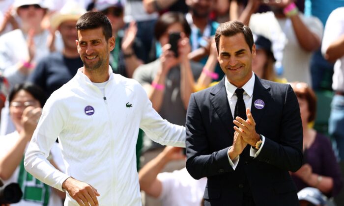 Swiss tennis player Roger Federer (R) and Serbia's Novak Djokovic take part in the Centre Court Centenary Ceremony, on the seventh day of the 2022 Wimbledon Championships at The All England Tennis Club in Wimbledon, southwest London, on July 3, 2022. (Adrian Dennis/AFP via Getty Images)