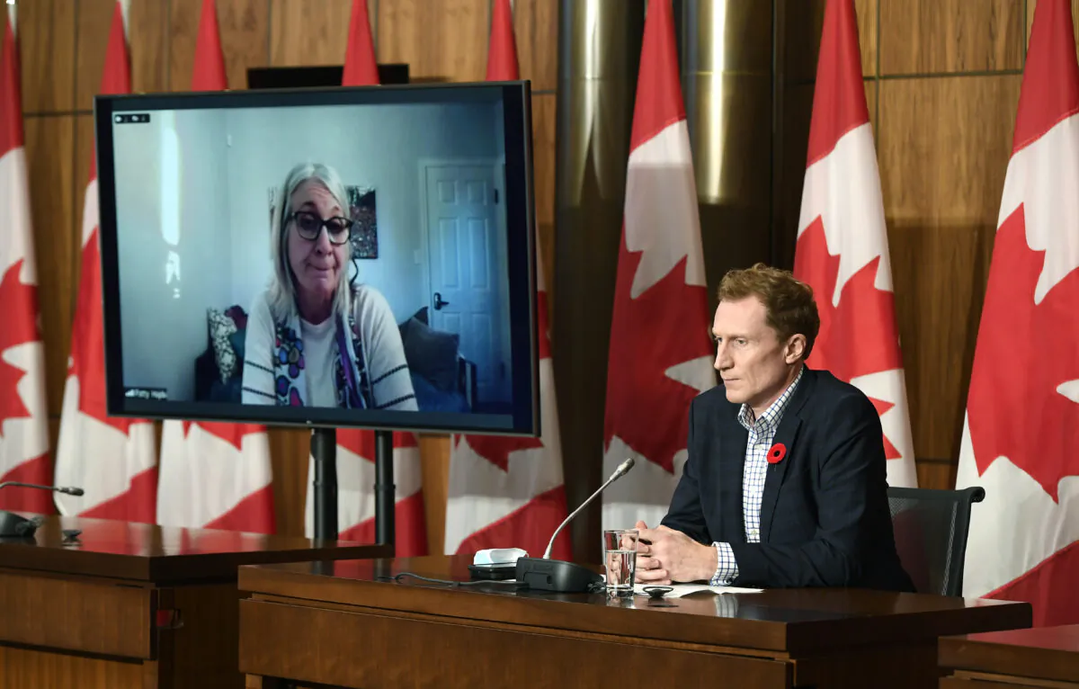 Minister of Crown-Indigenous Relations Marc Miller (R) listens as Minister of Indigenous Services Patty Hajdu, appearing via video conference, speaks during a news conference regarding the order from the Canadian Human Rights Tribunal to compensate Indigenous children and their families, in Ottawa on Oct. 29, 2021. (Justin Tang/The Canadian Press)