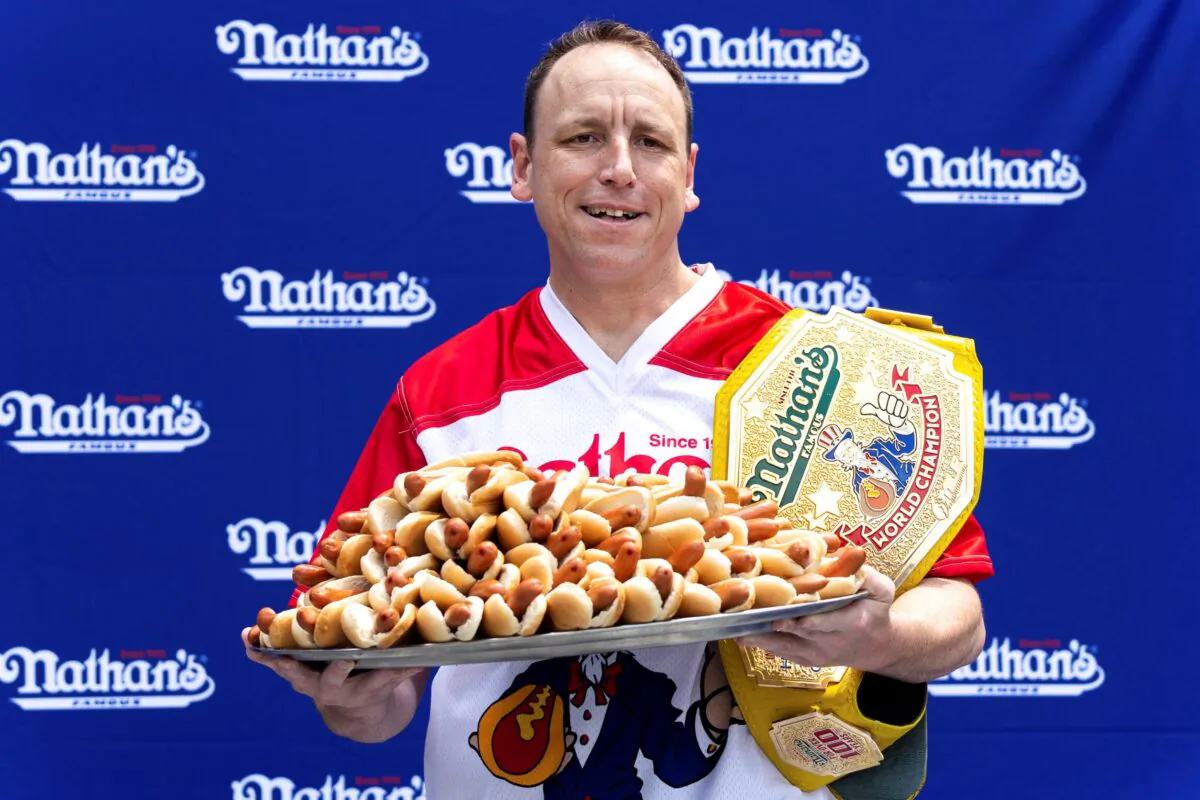 Competitive eater Joey Chestnut poses for photos with 76 hot dogs at a weigh-in before the Nathan's Famous July Fourth hot dog eating contest in New York on July 1, 2022. (Julia Nikhinson/AP Photo)